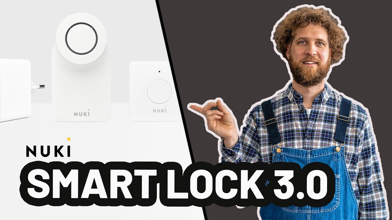 Vorschaubild: Tobias Haack in kariertem Hemd und Latzhose zeigt mit der Hand auf weiße Nuki-Geräte, darunter Schriftzug „Nuki Smart Lock 3.0“