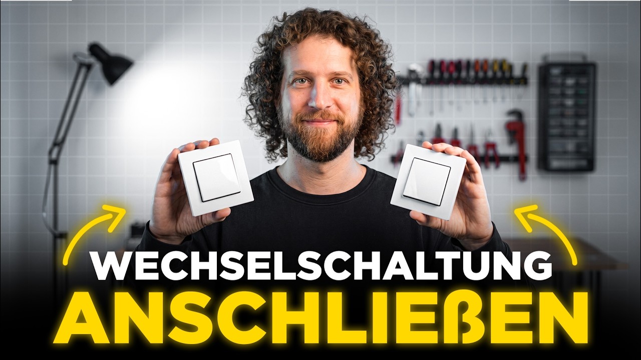 Tobias Haack hält zwei weiße Lichtschalter in die Kamera, darunter der Schriftzug Wechselschaltung anschließen